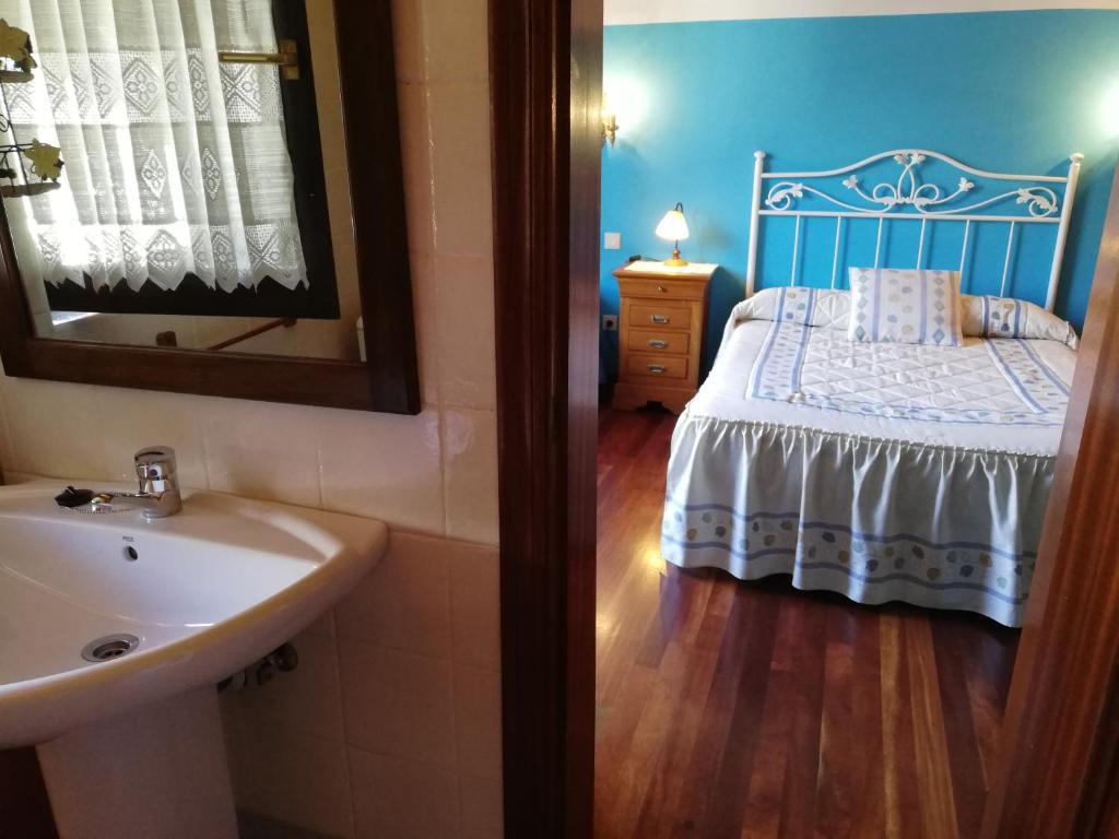 W łazience znajduje się łóżko z umywalką i lustrem. w obiekcie La Ermita w mieście Camaleño