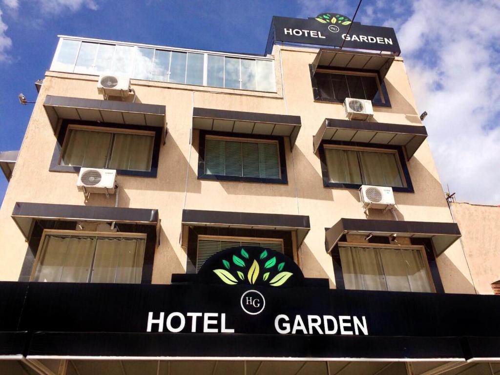 um edifício de hotel com uma placa em frente em Hotel Garden em Santa Maria