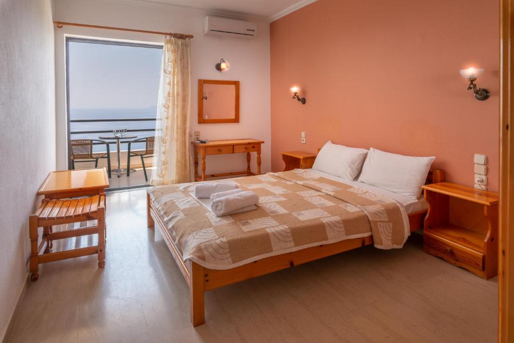 a bedroom with a bed with a view of the ocean at Arilla Beach Hotel in Perdika