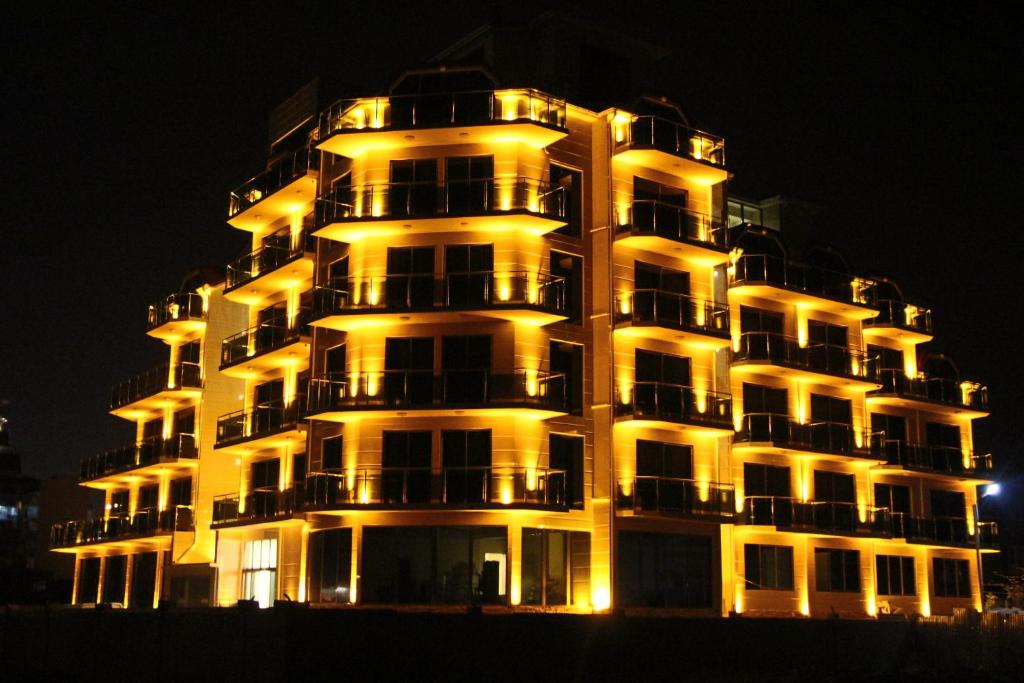 a tall apartment building with its lights on at night at Legacy Hotel in Batumi