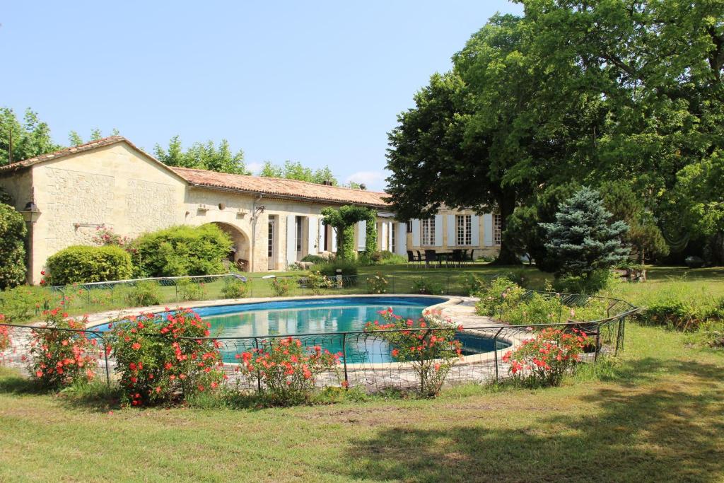 una casa con piscina en un patio en Château Rosemont - Grande maison familiale campagne dans le Médoc avec piscine et tennis à 15 mn Bordeaux en Labarde