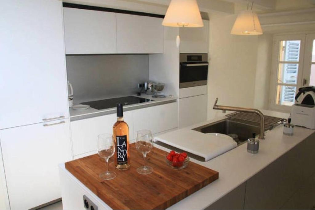 a kitchen with a bottle of wine on a counter at L’Ile Rousse les pieds dans l’eau in LʼÎle-Rousse