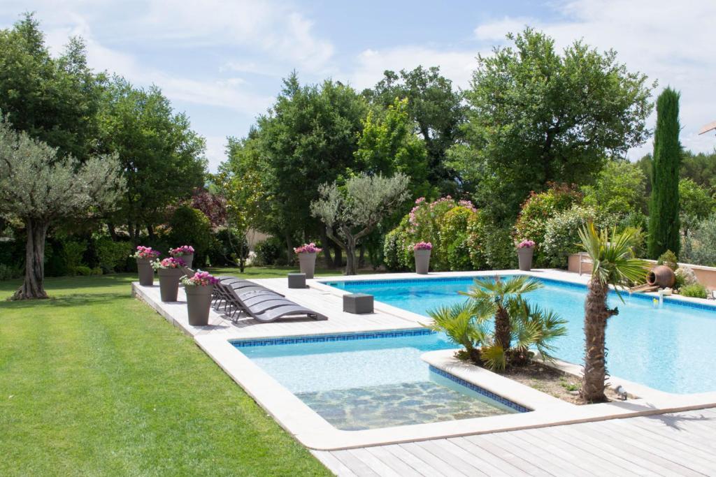 a swimming pool in a yard with trees at Le Bouquet de l Aromate in Joucas