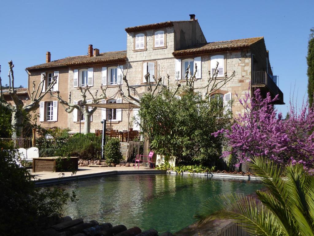 una casa grande con piscina frente a ella en Bed and Breakfast La Grande Lauzade, en Le Luc