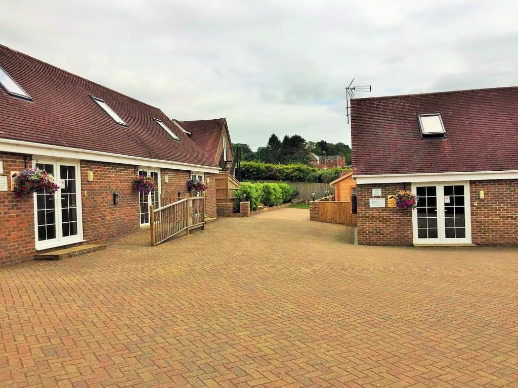 uma entrada de tijolos em frente a dois edifícios de tijolos em Forest Edge Motel em Ticehurst