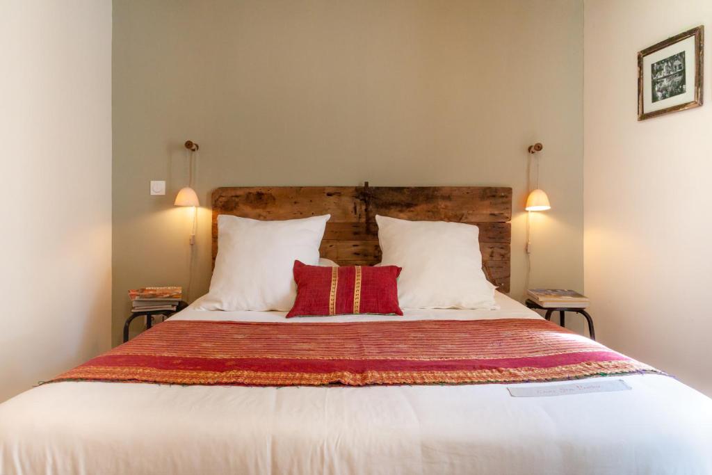 sypialnia z dużym łóżkiem z 2 czerwonymi poduszkami w obiekcie Gris Piedra Home w mieście Lourmarin