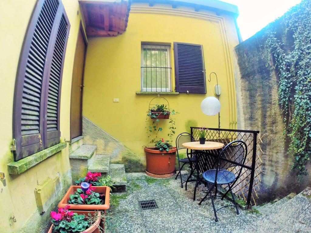 a small patio with a table and chairs in front of a building at Cozy Garden Retrait in Varenna