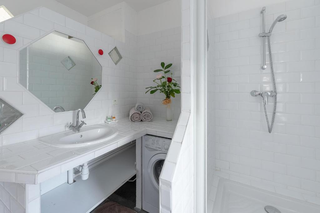 a white bathroom with a washing machine and a sink at My rima in Antibes