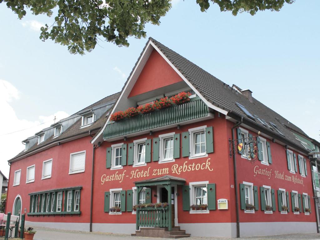 um edifício vermelho com flores na frente em Gasthof Hotel zum Rebstock em Malterdingen