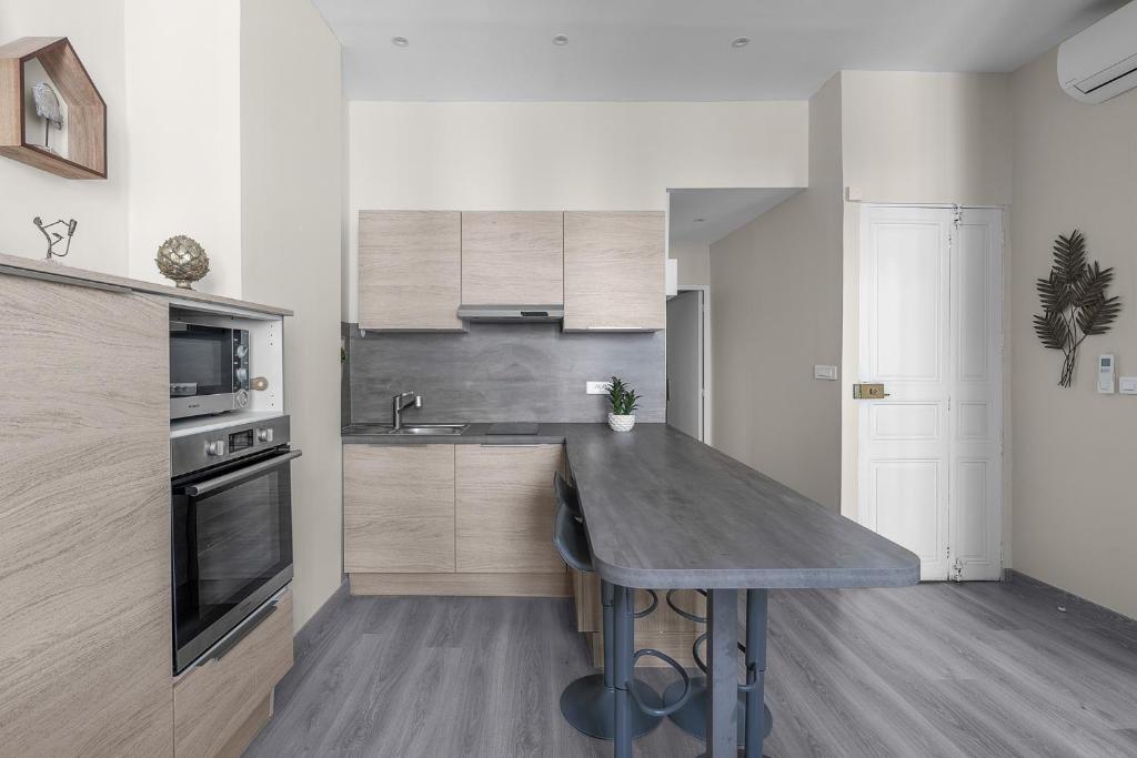 a kitchen with a wooden counter top and a table at My rima in Antibes