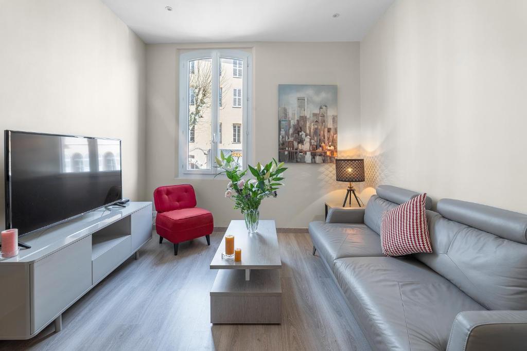 a living room with a couch and a flat screen tv at My rima in Antibes