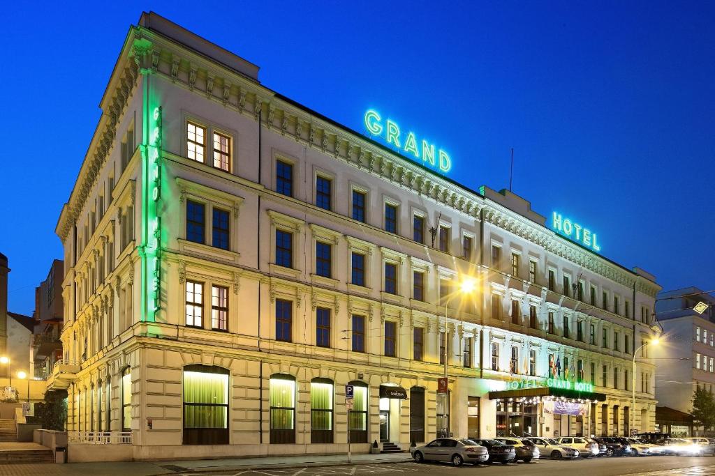 a building with a green sign on top of it at Grandhotel Brno in Brno