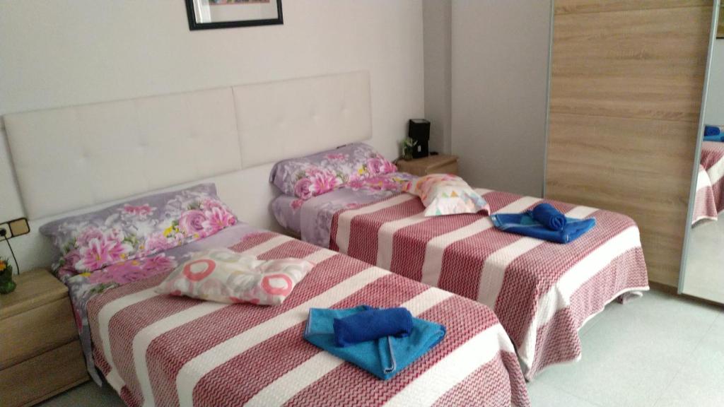 two beds in a room with blue bows at El Campello in El Campello