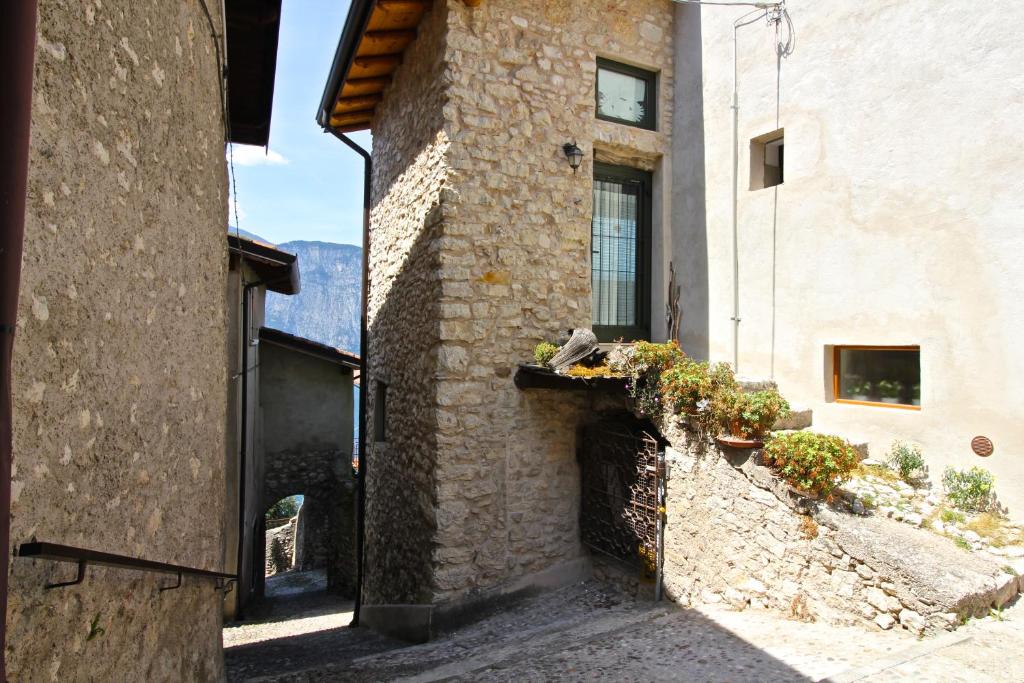 Une allée dans un vieux bâtiment en pierre avec des plantes dans l'établissement Ca de l'Angelon - Apartment Sardella, à Brenzone
