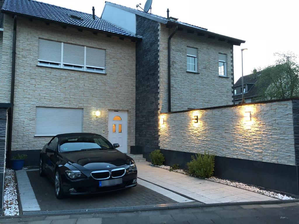 een zwarte auto geparkeerd voor een huis bij Zimmervermietung Roy in Keulen