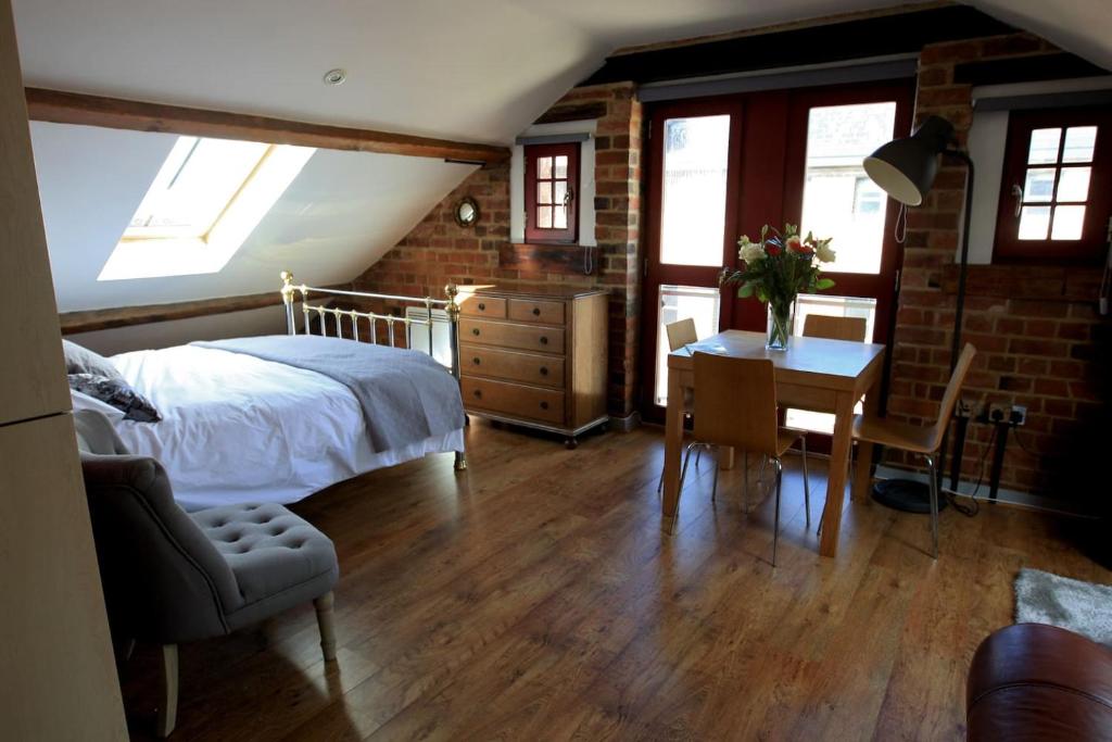 Un dormitorio con una cama y un escritorio con una mesa. en Victorian Penthouse Apartment, en Gloucester