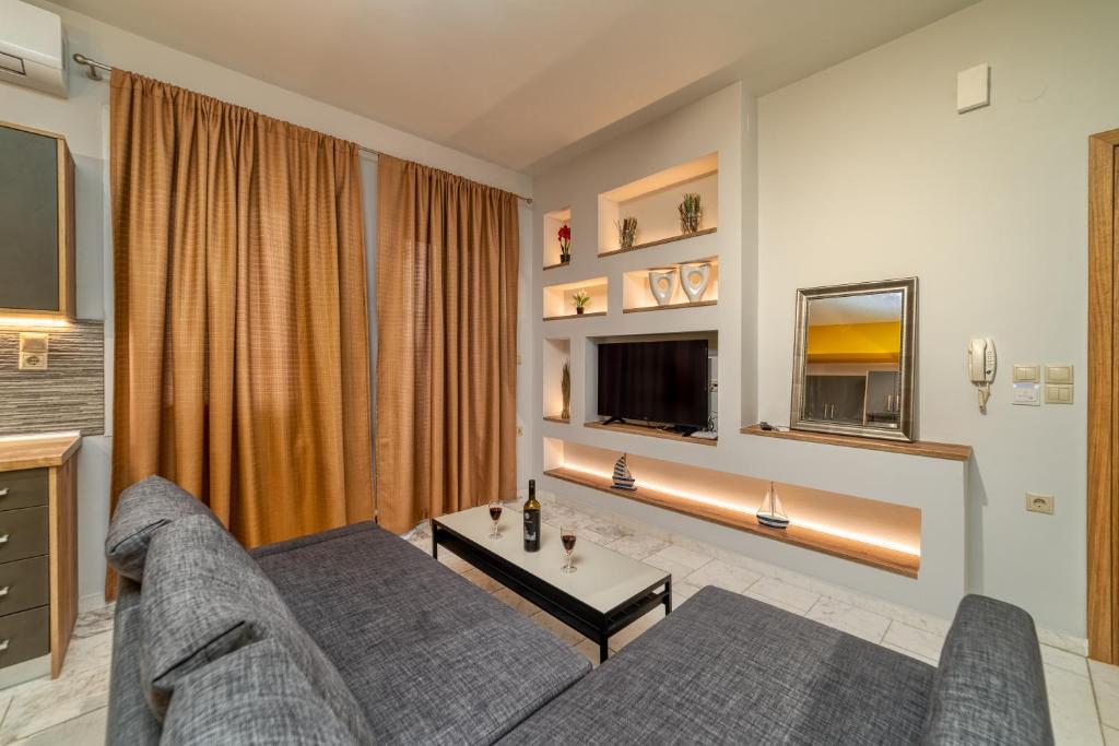 a living room with a couch and a tv at Amoudara Suites in Amoudara Herakliou