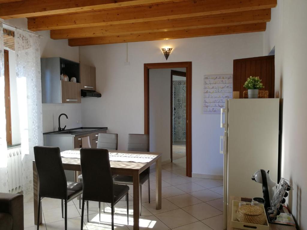 eine Küche mit einem Tisch und Stühlen sowie einem Kühlschrank in der Unterkunft La Corte dell'Angelo in Orio al Serio
