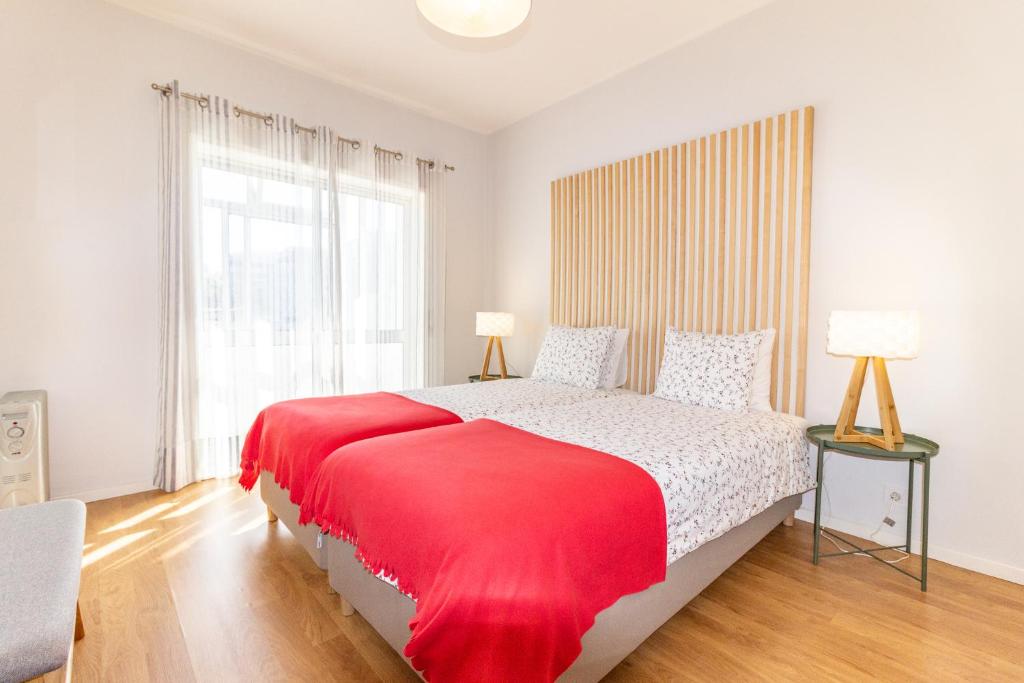 a bedroom with a large bed with a red blanket at Cedofeita 408, Green in Porto
