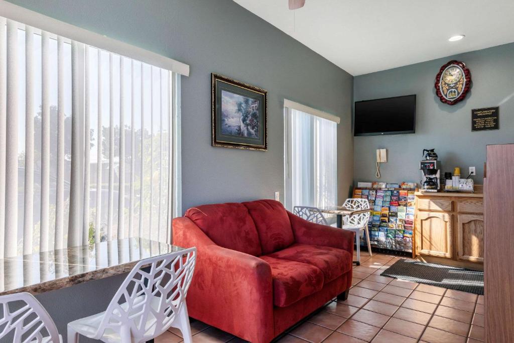 sala de estar con sofá rojo y mesa de cristal en Rodeway Inn Carson - Los Angeles South, en Carson