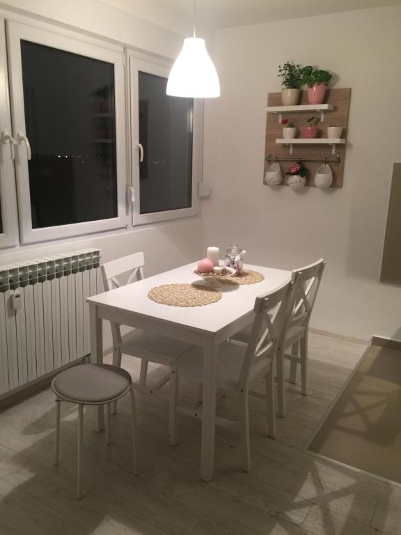 Maja’s lovely place في فيليكا غوريكا: طاولة بيضاء وكراسي في غرفة مع نافذة