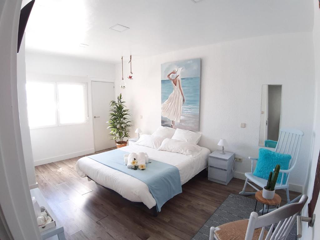 un dormitorio con una cama con un perro sentado en ella en Ananda Beach Rooms, en Peñíscola