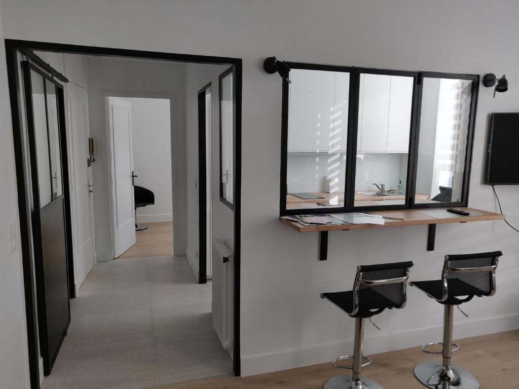 un couloir avec un miroir et deux tabourets dans l'établissement Cosy apartment, à Cannes