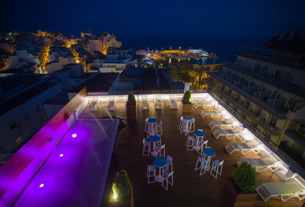 een patio met tafels en stoelen in de nacht bij Hotel Voramar in Benidorm