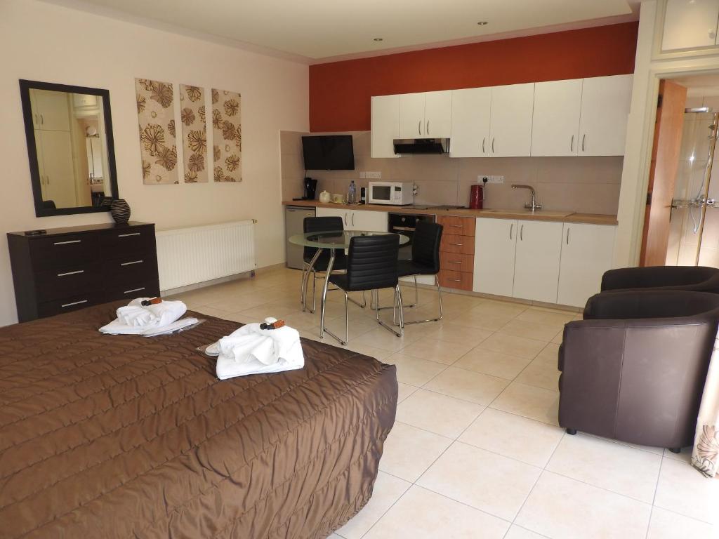 a bedroom with a bed with two towels on it at Hill View Hotel Apartments in Pissouri