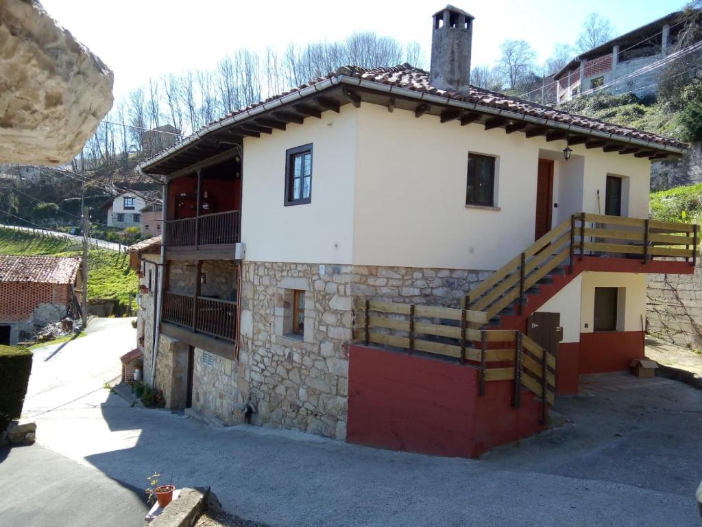 a house with a red door and a balcony at los Balcones de Nieda in Cangas de Onís