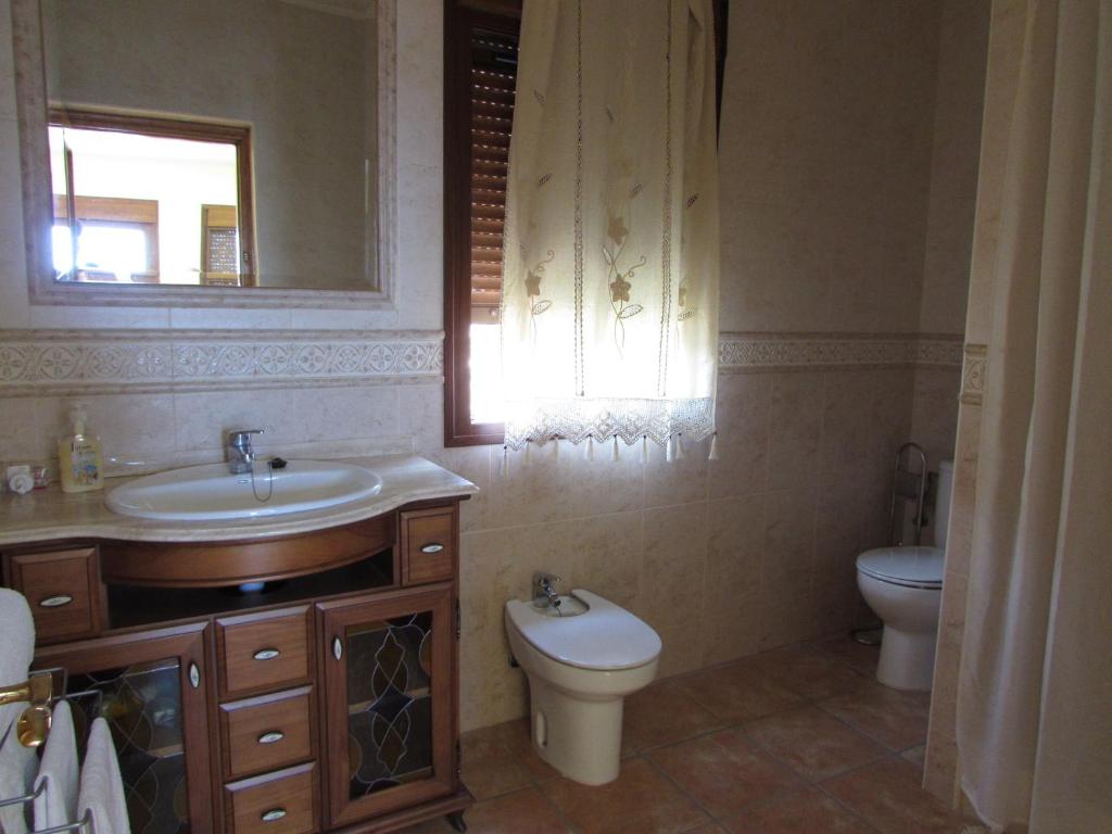 baño con lavabo y aseo y ventana en ALBARICO RETREAT, en Bédar