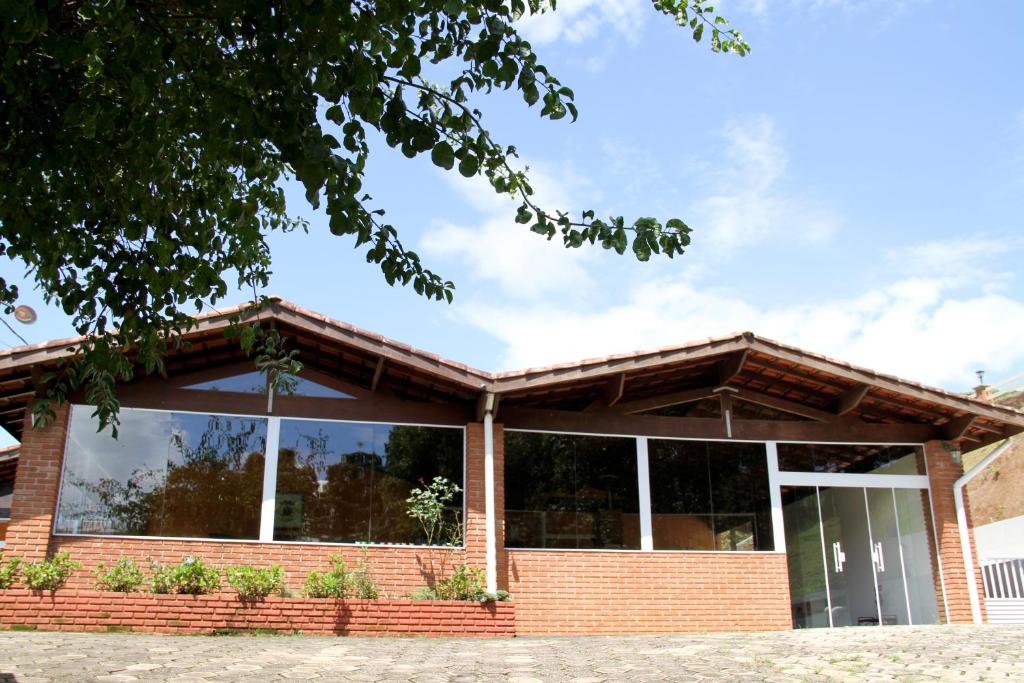 a brick building with large windows at Pousada Sol Da Montanha in Jardim Sun Valley