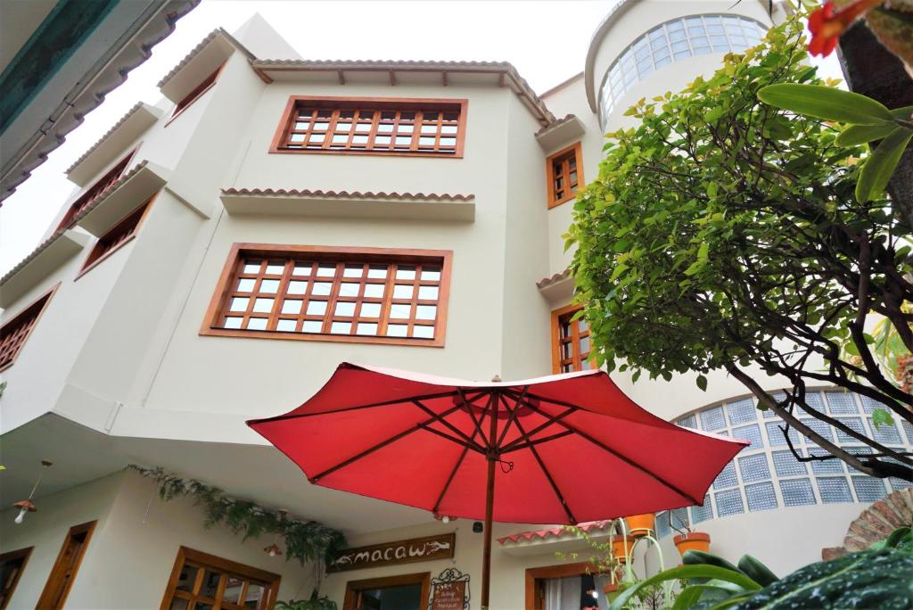 um guarda-chuva vermelho em frente a um edifício em Hostal Macaw em Guayaquil