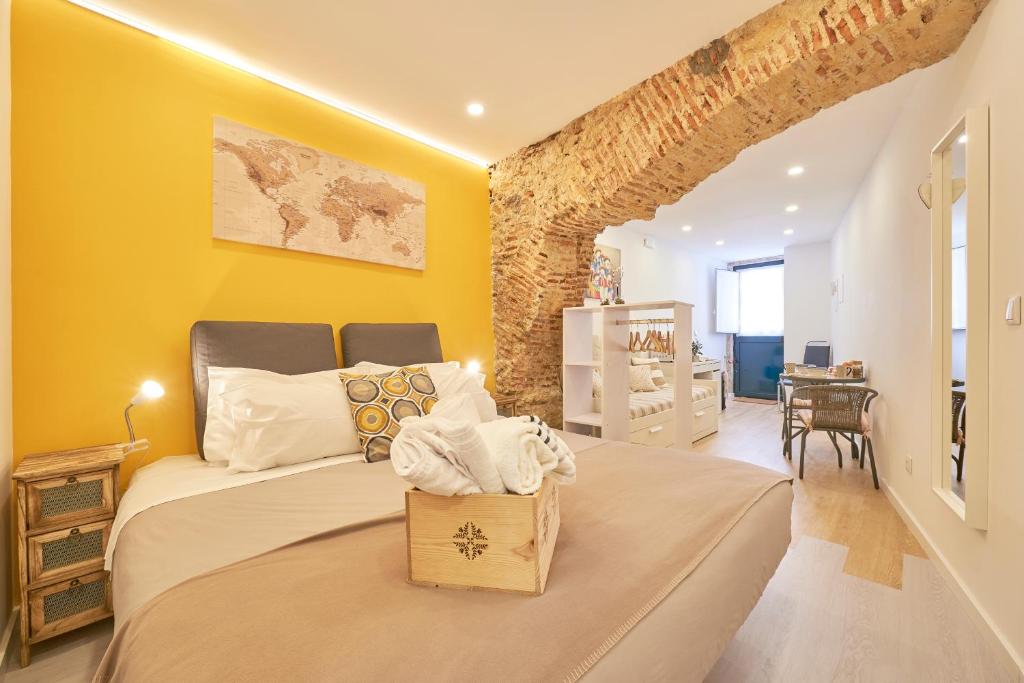 1 dormitorio con 1 cama grande y paredes amarillas en Lisbon Inn Bica Suites, en Lisboa