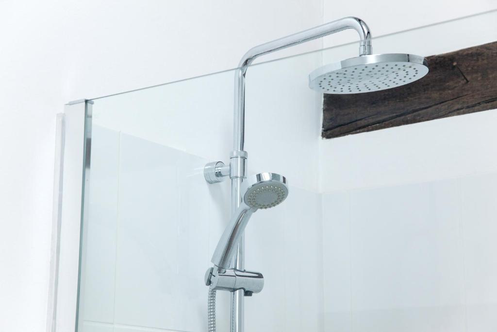 a shower with a shower head in a bathroom at Stable Cottage, Oxfordshire in Oxford