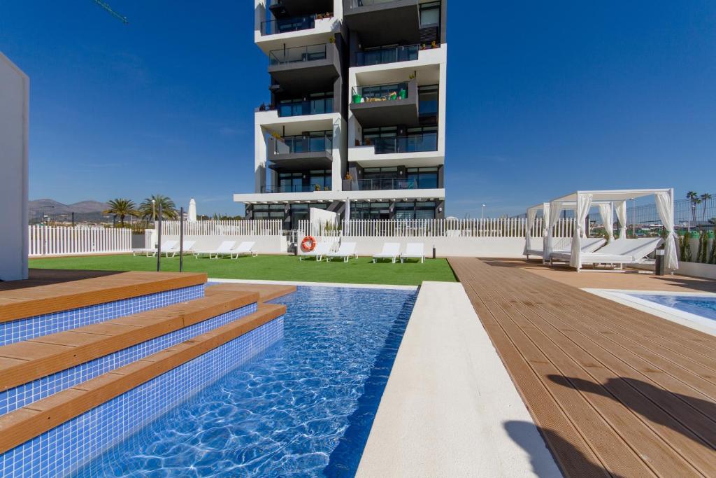 a hotel with a swimming pool and a building at Urbano Blanco Apartments in Calpe