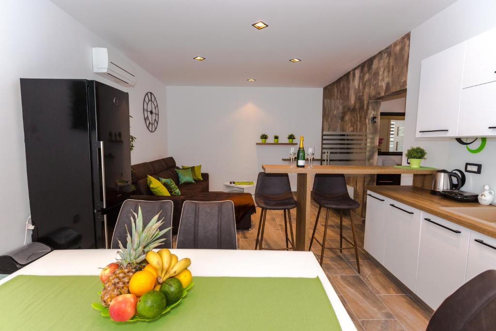 a kitchen with a table with a bowl of fruit on it at Sensitive relax apartment in Rijeka