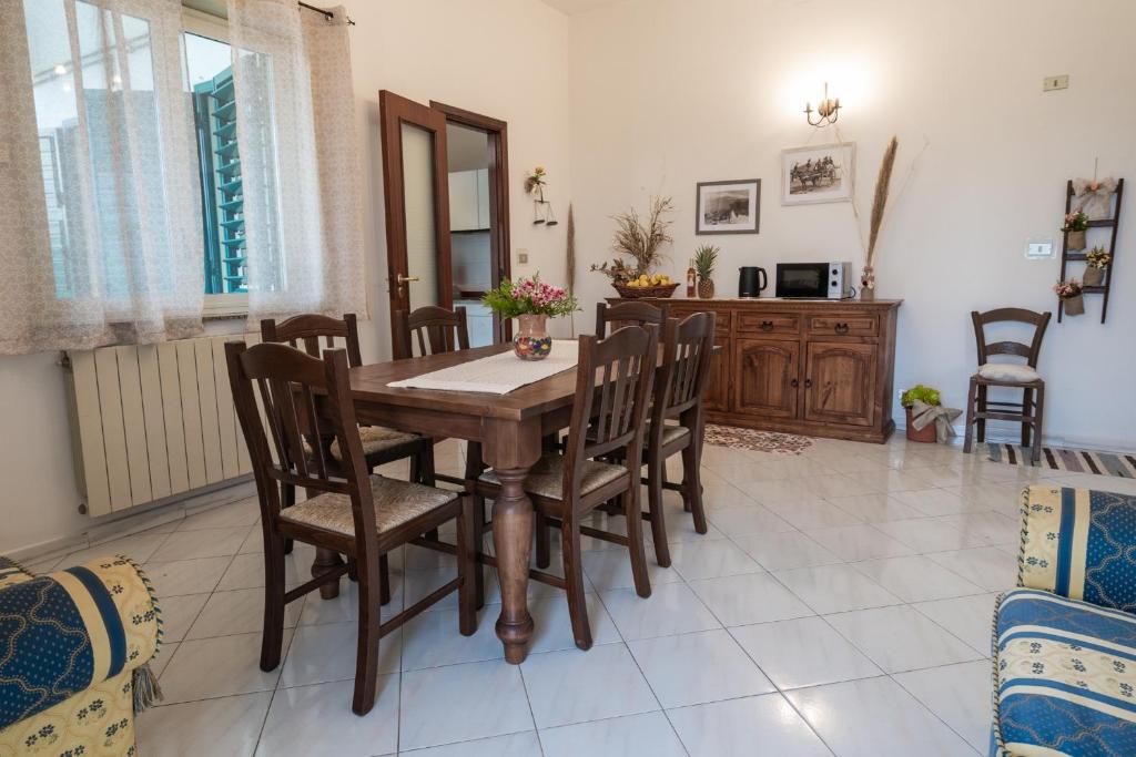 a dining room with a wooden table and chairs at Casa Rosario in Riposto