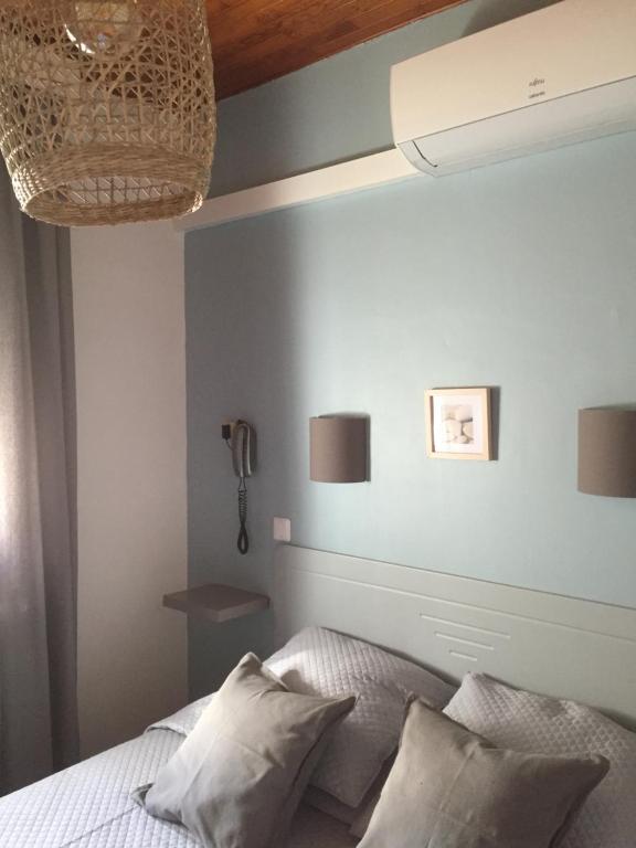 a bedroom with a blue wall and a bed with pillows at Hotel Le Méditérranée in Saintes-Maries-de-la-Mer