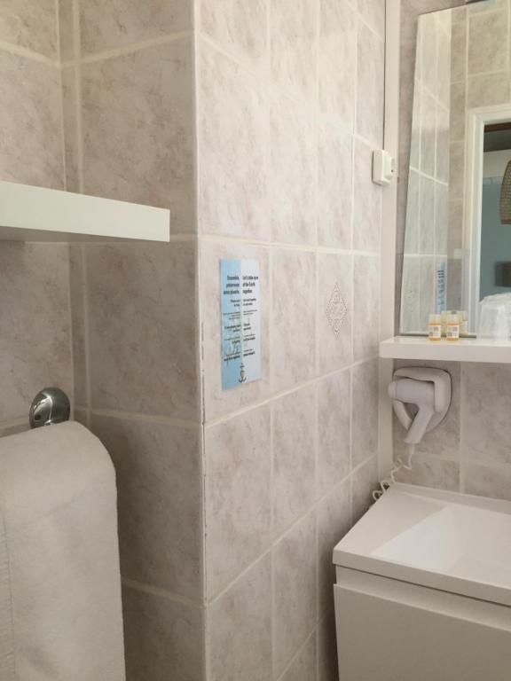 a bathroom with a sink and a toilet and a mirror at Hotel Le Méditérranée in Saintes-Maries-de-la-Mer