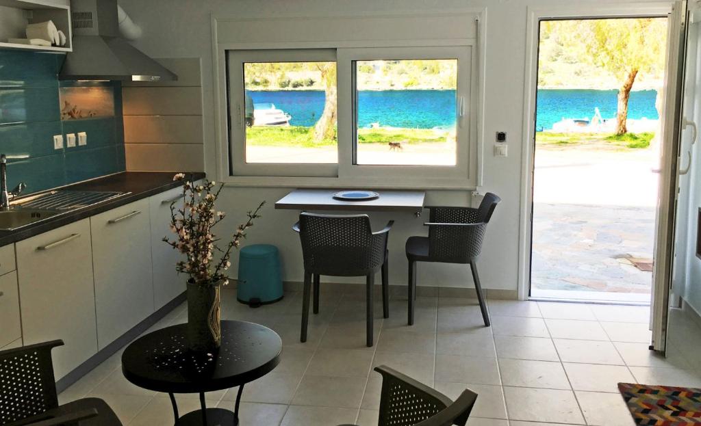 a kitchen with a table and chairs and a view of the ocean at Sea Front Studio - Porto Boufalo - Evia in Boufalo