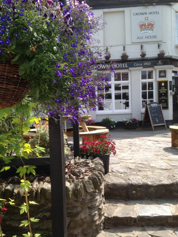 een bos bloemen op een paal voor een gebouw bij The Crown Hotel in Lynton