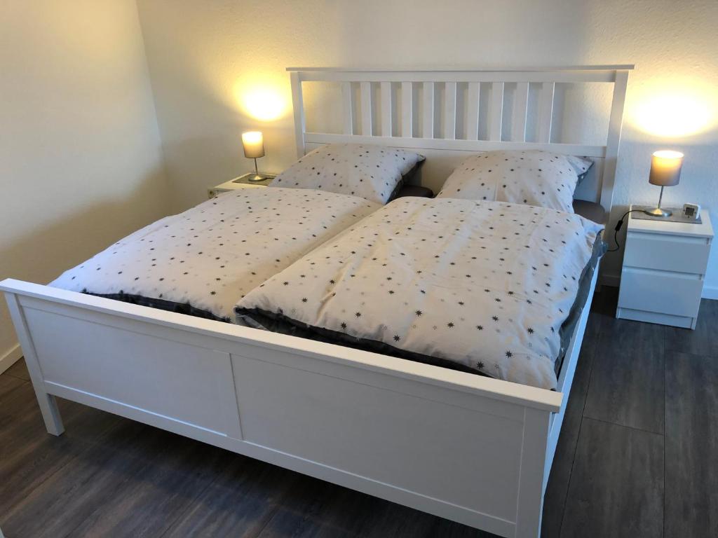 1 cama blanca con 2 almohadas en el dormitorio en Ferienwohnung "am Ochsentor", en Andernach