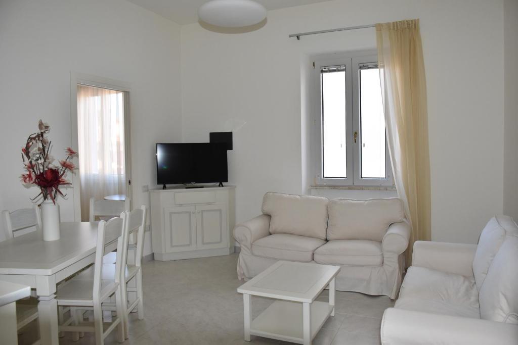 un soggiorno bianco con divano bianco e tavolo di casa Pepi a Olbia