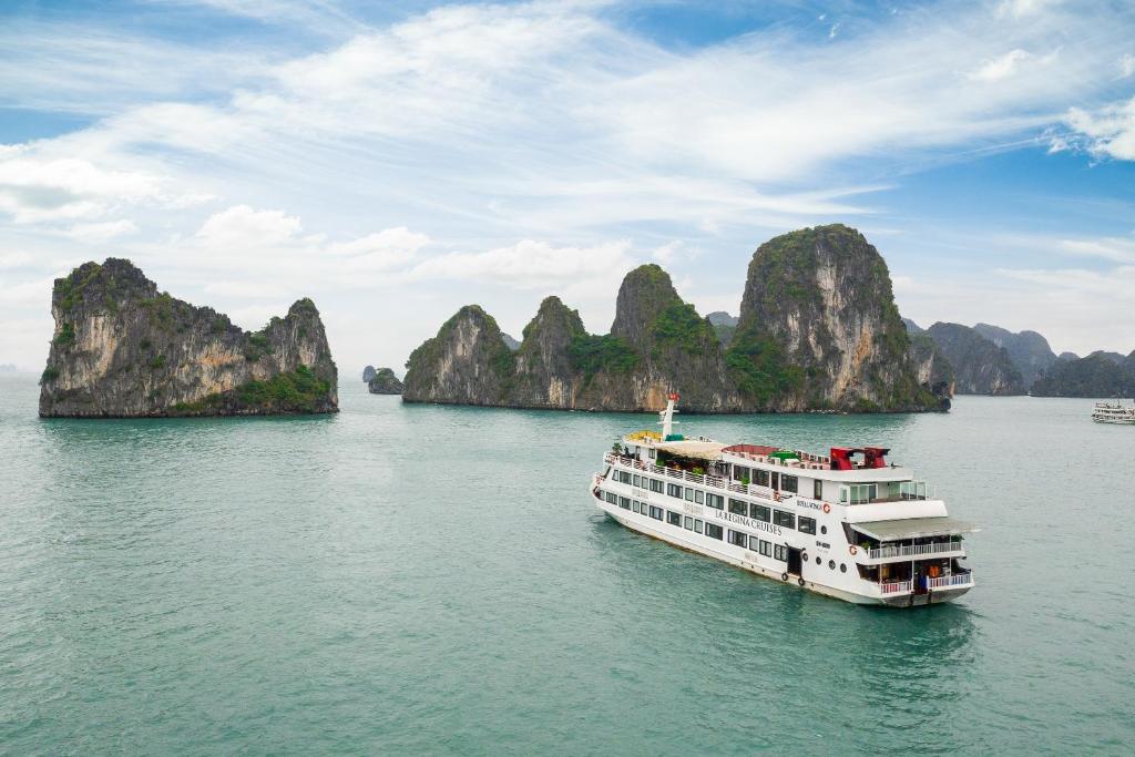 a cruise ship in halong bay with limestone cliffs at La Regina Royal Cruise in Ha Long