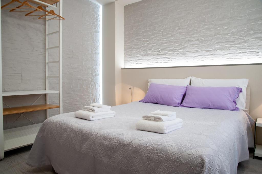Un dormitorio con una cama blanca con toallas. en La Corte, en Alessandria