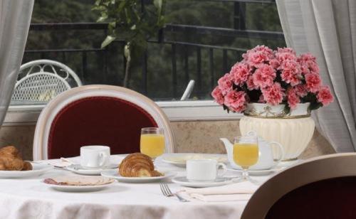 uma mesa com pratos de comida e um vaso de flores em Hotel Eliseo em Roma