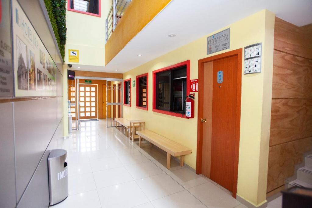 un pasillo de un edificio con bancos y mesas en Hotel Lira - Sólo Adultos, en Ciudad de México