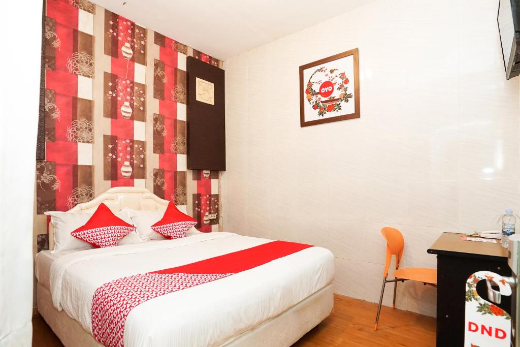 una camera con un letto con una coperta rossa e bianca di OYO 425 Mojokerto Guesthouse a Mojokerto