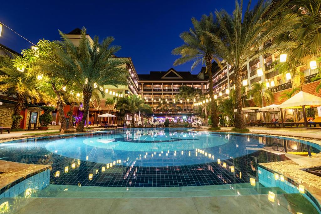 Empress Residence Resort and Spa في سيام ريب: مسبح كبير في منتجع في الليل